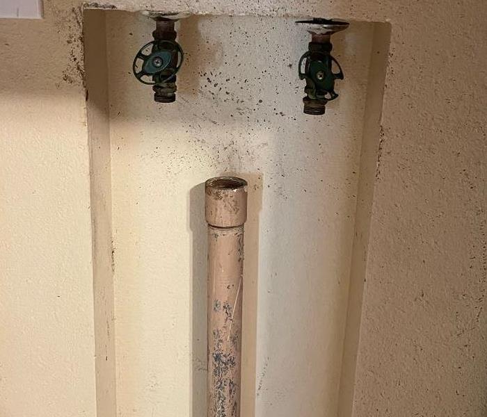 Three pipes that are disconnected in a wall